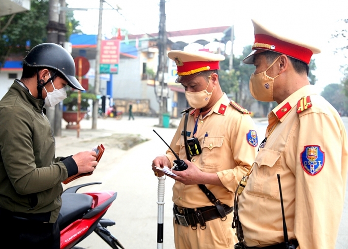 Lực lượng Cảnh sát giao thông kiểm tra giấy tờ xe của người tham gia giao thông. Ảnh: T.L