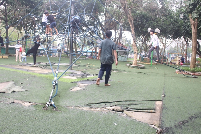 Thảm cỏ nhân tạo tại khu vực vui chơi cho trẻ em bị rách nát, lởm chởm mảng bê tông lớn. Ảnh: Mộc Miên