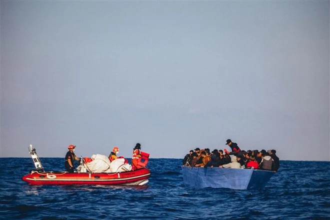 Lực lượng cứu hộ giải cứu người di cư ngoài khơi bờ biển Libya. (Ảnh: AFP