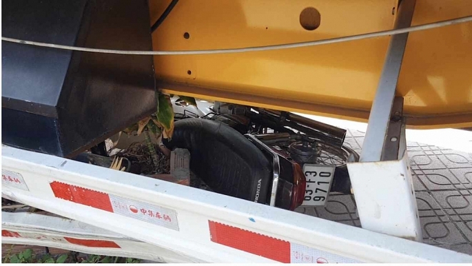 Xe máy bị cuốn vào gầm xe container Ảnh: CT