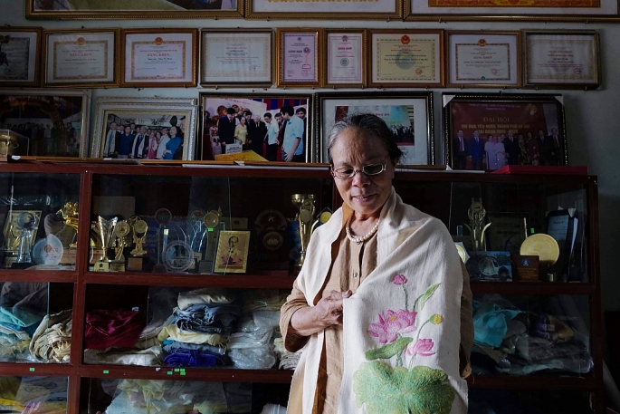 Nghệ nhân ưu tú Phan Thị Thuận giới thiệu chiếc khăn lụa từ tơ sen. Ảnh: Khánh Huy