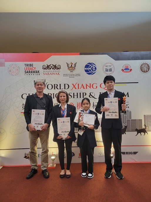Nguyễn Thiên Kim và gia đình trên sân khấu nhận cúp huy chương Bạc môn Cờ tướng tại Giải trẻ thế giới tổ chức tại Malaysia năm 2023. Ảnh: Quốc Chính