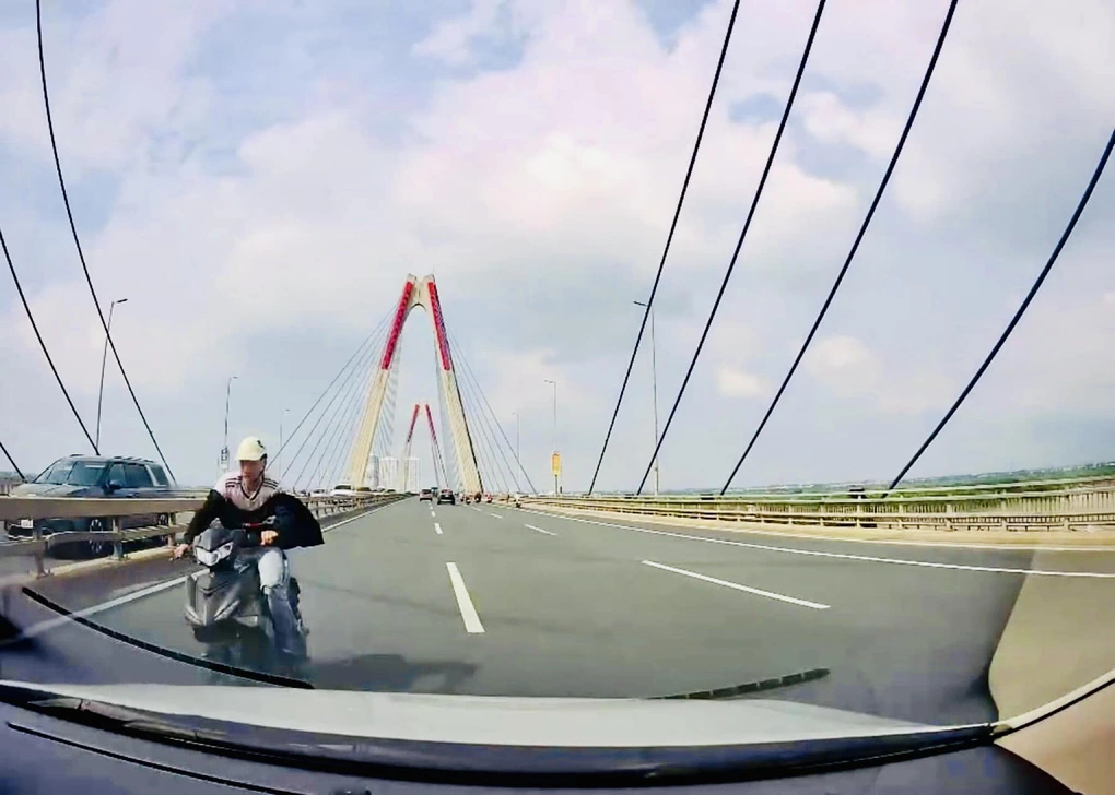T. điều khiển xe máy đi ngược chiều trên cầu Nhật Tân. Ảnh: CQCA