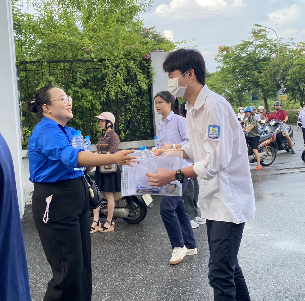 Cổng trường bị ngập nước, thanh niên tình nguyện "xếp" đường cho thí sinh di chuyển vào phòng thi