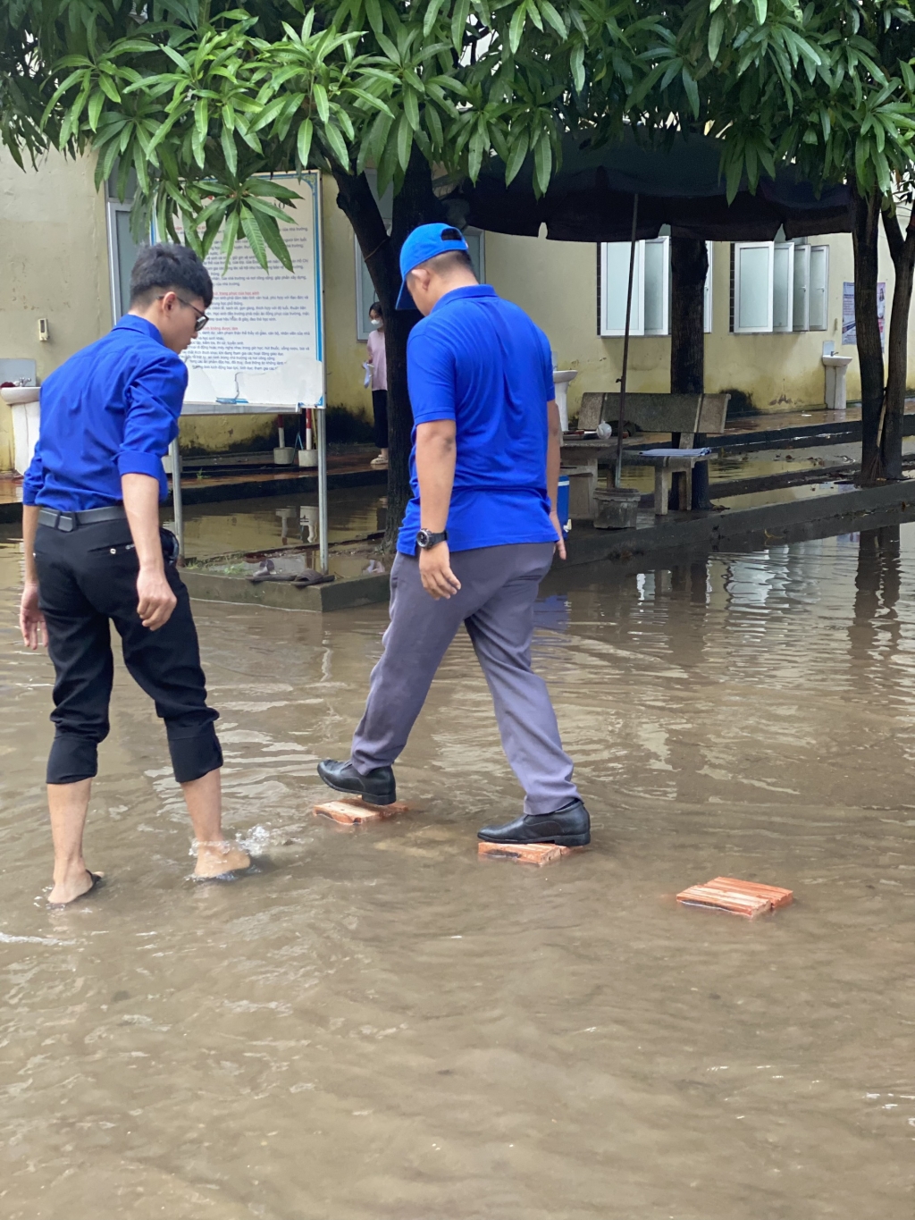 Cổng trường bị ngập nước, thanh niên tình nguyện 