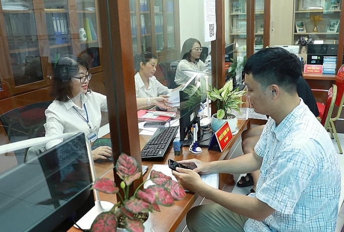 Giải quyết thủ tục hành chính cho người dân tại bộ phận “một cửa” UBND phường Hàng Bài (quận Hoàn Kiếm). Ảnh: Nguyễn Quang