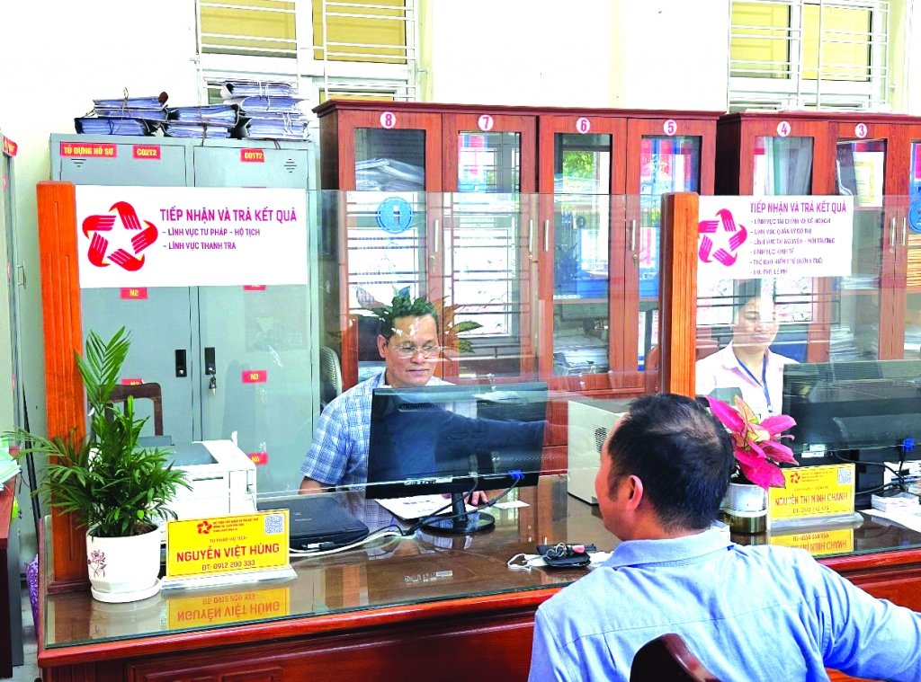 Giải quyết thủ tục hành chính về hộ tịch - tư pháp cho người dân tại bộ phận “Một cửa” UBND thị trấn Sóc Sơn, Hà Nội Ảnh: Bạch Dương