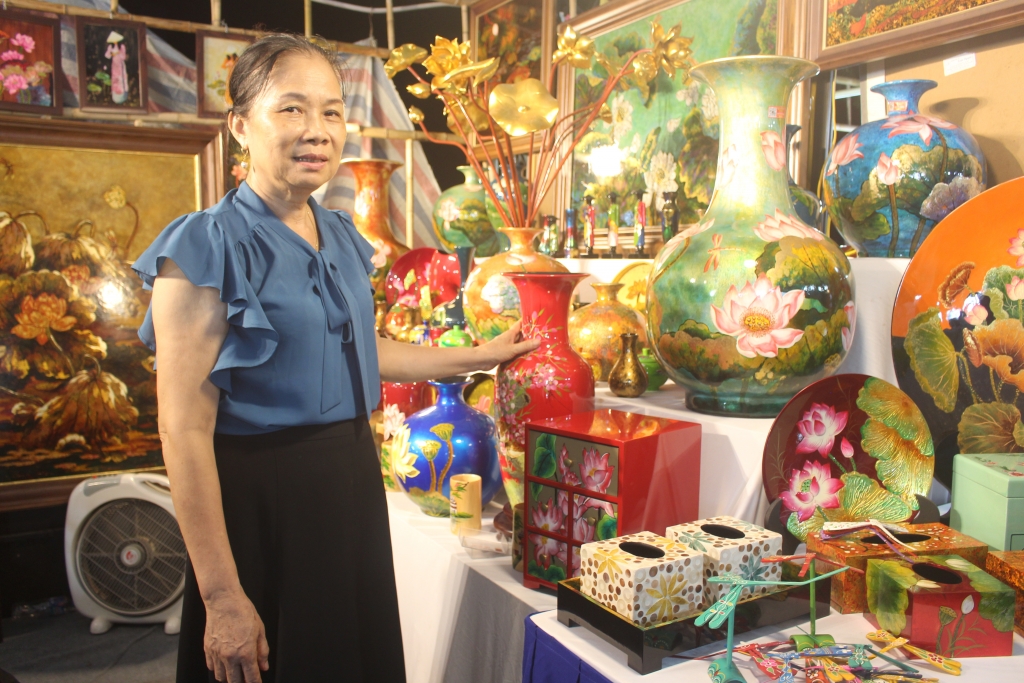 Nghệ nhân ưu tú Nguyễn Thị Hồi giới thiệu sản phẩm sơn mài làng nghề Hạ Thái. Ảnh: Mộc Miên