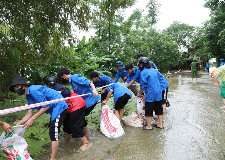 Thanh niên tình nguyện thôn Tân Tiến, xã Nam Phương Tiến (huyện Chương Mỹ) hỗ trợ bảo đảm vệ sinh môi trường tại vùng lũ.