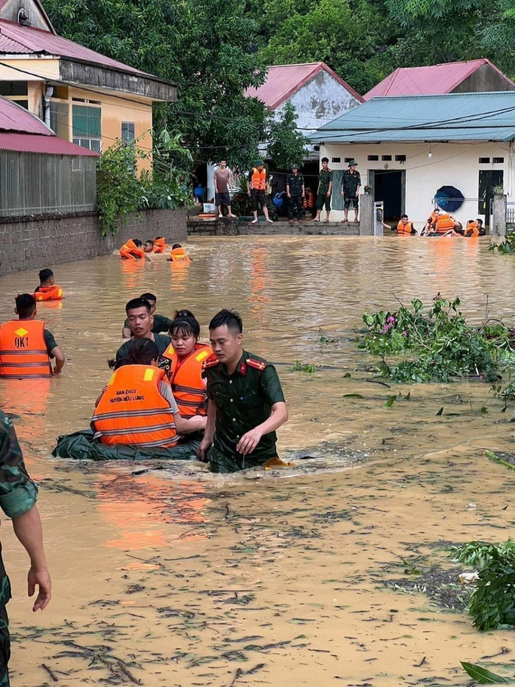 Lực lượng ứng trực hỗ trợ người dân thoát khỏi vùng trũng ngập úng.