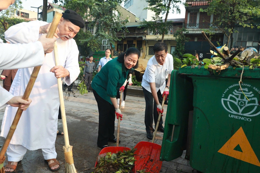 Bí thư Thành ủy Bùi Thị Minh Hoài tham gia dọn cành cây cùng người dân tại Vườn hoa Vạn Xuân.