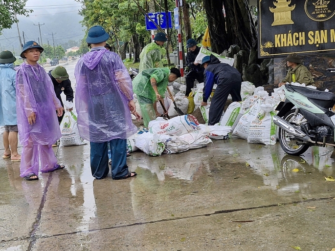 Hỗ trợ xã Hương Sơn đắp đê bao cát ngăn nước. Ảnh: V. Biên