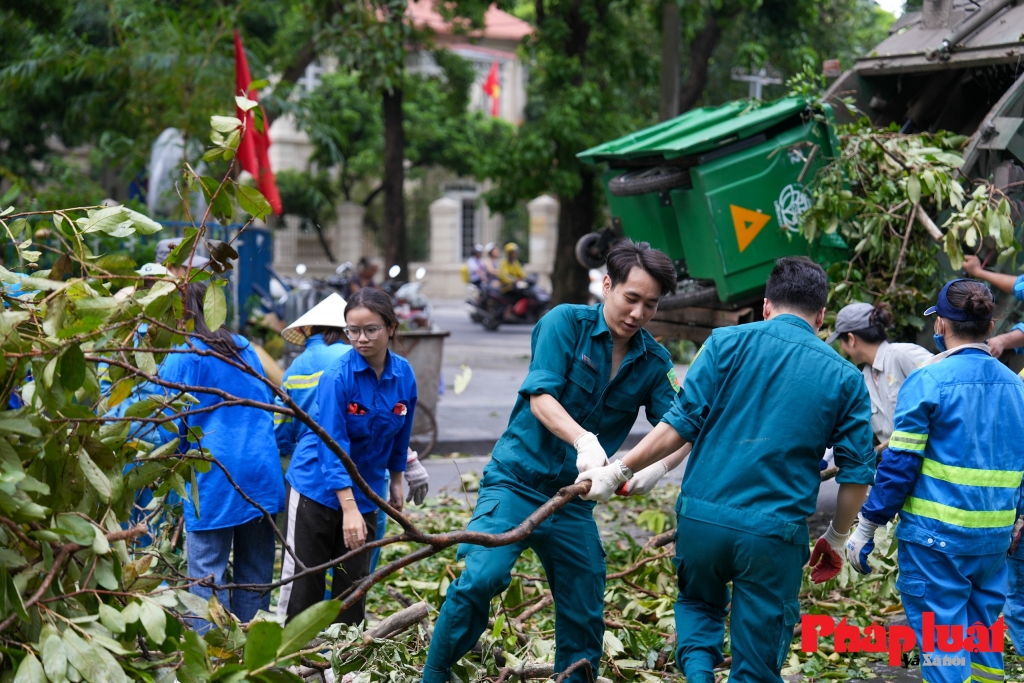 Cán bộ, chiến sĩ cùng lực lượng dân quân, đoàn viên thanh niên dọn dẹp cây xanh bị gãy đổ do bão số 3 quanh khu vực hồ Hoàn Kiếm, Hà Nội. Ảnh: Khánh Huy