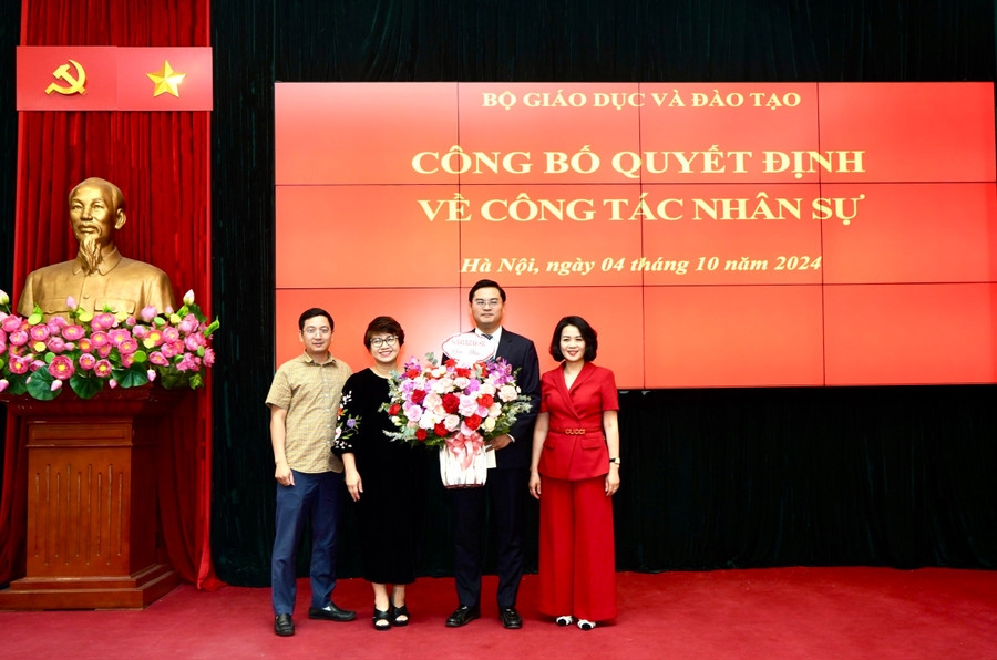 Lãnh đạo Vụ Giáo dục Đại học tặng hoa chúc mừng tân Phó Vụ trưởng Đặng Văn Huấn.