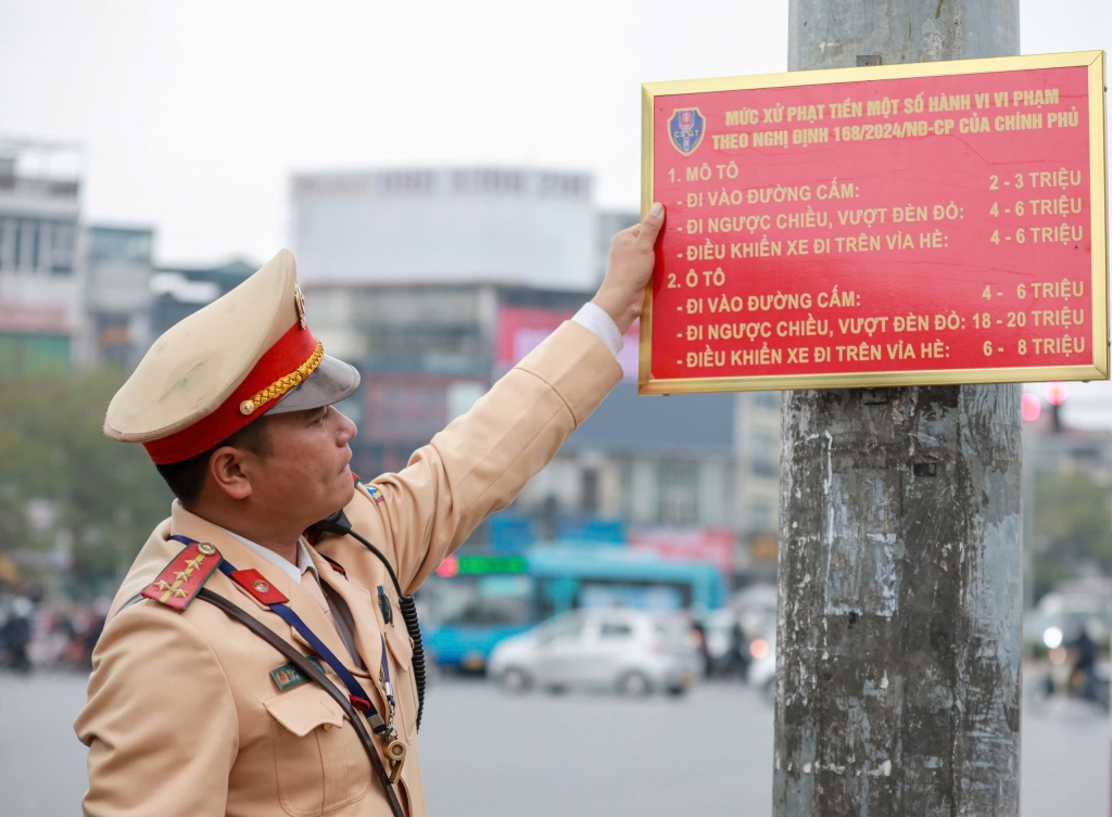 Lắp biển tuyên truyền tại nút giao trọng điểm Đại Cồ Việt - Giải Phóng. Ảnh: PV