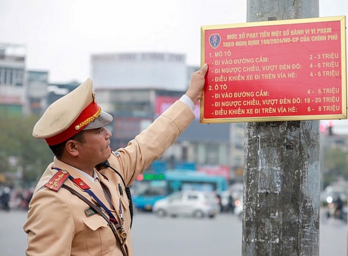 Cảnh sát giao thông, Công an TP  Hà Nội treo bảng tuyên truyền mức xử phạt theo Nghị định 168/2024/NĐ-CP tại ngã tư Đại Cồ Việt – Giải Phóng. Ảnh: Tiến Trạch