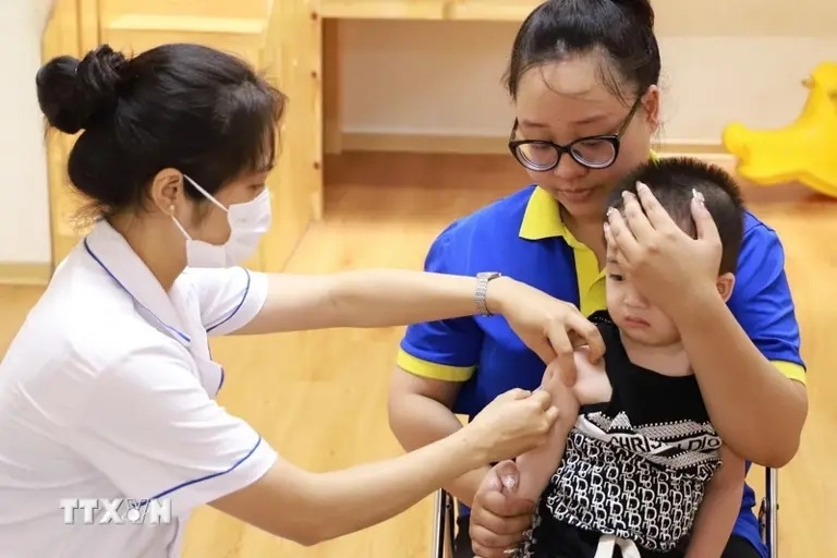 Nhân viên y tế tiêm vaccine phòng bệnh sởi cho trẻ tại điểm tiêm phường Chương Dương, quận Hoàn Kiếm. Ảnh: Vân Chi/TTXVN