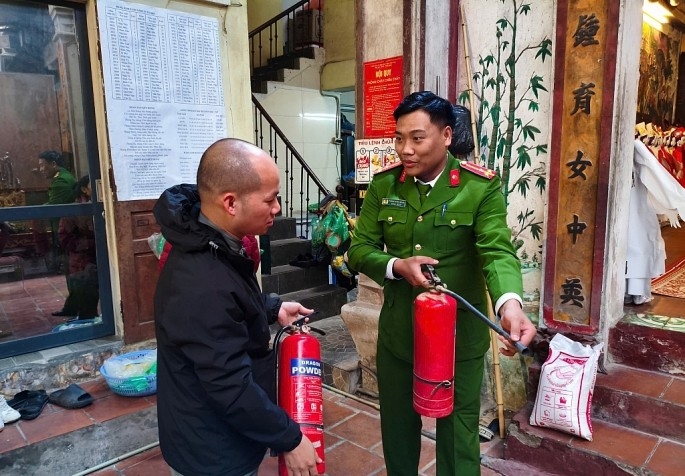 Công an quận Hoàn Kiếm tuyên truyền, hướng dẫn phòng cháy chữa cháy nơi cơ sở văn hóa, tín ngưỡng. Ảnh: PV