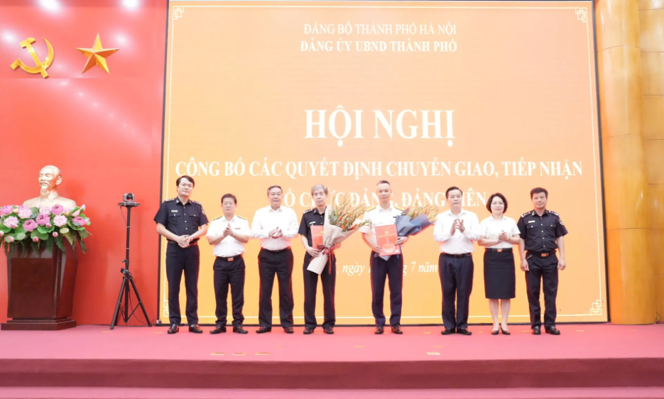 Ủy viên Ban Thường vụ Thành ủy, Phó Bí thư Thường trực Đảng ủy UBND TP, Phó Chủ tịch Thường trực UBND TP Hà Nội Lê Hồng Sơn và Phó Trưởng Ban Tổ chức Thành ủy Hà Nội Lê Trung Kiên tặng hoa, trao các quyết định chuyển giao, tiếp nhận 2 đảng bộ cấp trên cơ sở trực thuộc Thành ủy Hà Nội về trực thuộc Đảng ủy UBND TP Hà Nội, ngày 17/7/2025.