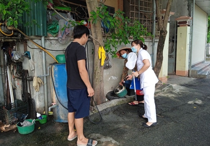 Cán bộ y tế tuyên truyền, hướng dẫn người dân vệ sinh môi trường phòng chống dịch bệnh sốt xuất huyết. Ảnh: Sở Y tế Hà Nội
