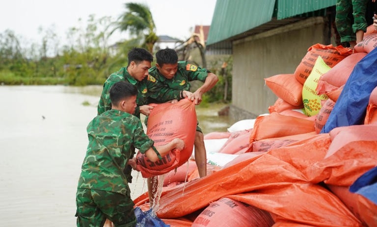 cán bộ, chiến sĩ đơn vị đã được phân công xuống tận các nơi hỗ trợ. Mục tiêu là hạn chế tối đa thiệt hại, giúp bà con sớm ổn định sản xuất sau bão. Ảnh: Báo Tiền phongNhững bao lúa được đưa lên từ ao hồ, ướt sũng nước.