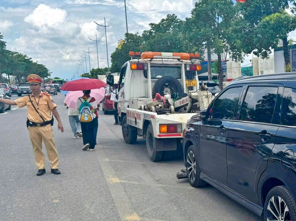 CSGT tiến hành cẩu kéo, xử lý xe dừng đỗ sai quy định gây cản trở giao thông.