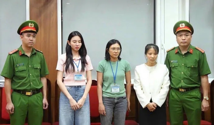 Hoa hậu Thùy Tiên (trái) tại thời điểm bị khởi tố. Ảnh Bộ Công an.