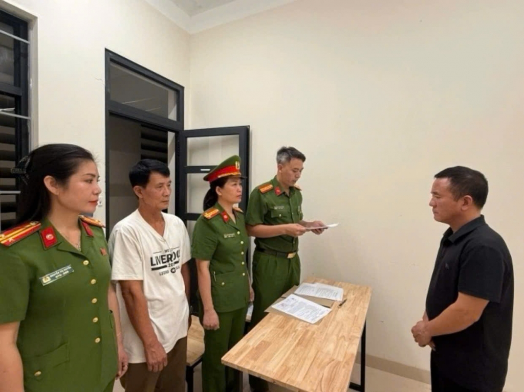 Cơ quan chức năng tống đạt quyết định khởi tố bị can. Ảnh: Bộ CA)