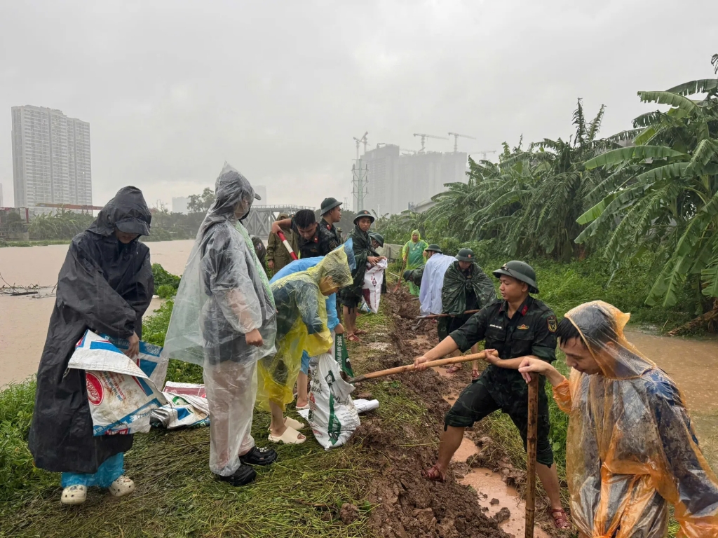 Chung tay cùng người dân gia cố đê xung yếu sau hoàn lưu bão số 10. Ảnh P.T