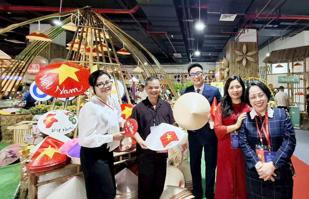 Nghệ nhân Lê Văn Tuy giới thiệu sản phẩm nón lá làng Chuông tới đại biểu và du khách tại Triển lãm thành tựu Đất nước dịp kỷ niệm 80 năm Ngày Quốc khánh. Ảnh: Ngọc Ánh 