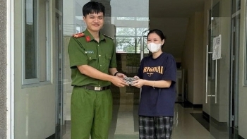 Cô gái trẻ vui mừng nhận lại chiếc ví từ chiến sỹ Công an