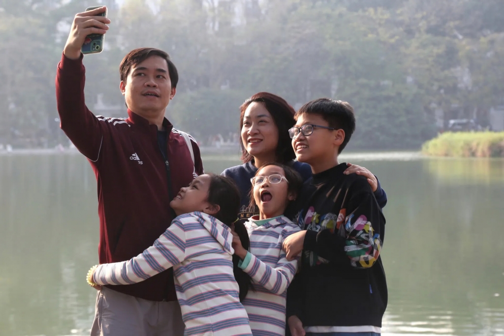 Một gia đình nhỏ lưu lại khoảnh khắc hạnh phúc bên bờ hồ Hoàn Kiếm. Ảnh Tuyết Linh