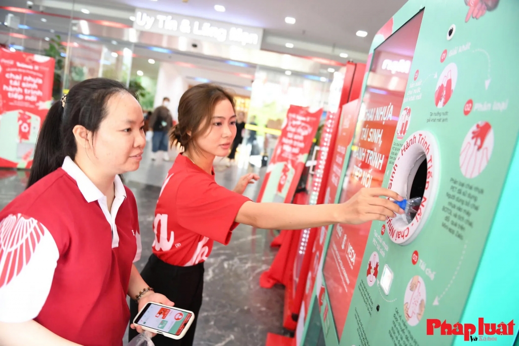 Các sinh viên trải nghiệm sử dụng máy thu gom vỏ chai nhựa trong chương trình “Chai nhựa tái sinh, hành trình tiếp nối” tại Trường Đại học Thương mại (Hà Nội). Ảnh Khánh Huy