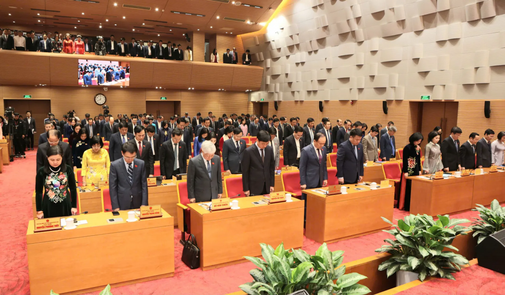 Các đại biểu tham dự phiên khai mạc dành 1 phút mặc niệm nhằm chia sẻ những mất mát với đồng bào miền Trung, Tây Nguyên bị thiệt hại do mưa, lũ gây ra