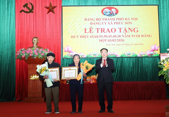 Đồng chí Phan Văn Sự - Bí thư Đảng ủy,Chủ tịch HĐND xã Phúc Sơn trao Huy hiệu Đảng viên trong Đảng bộ.