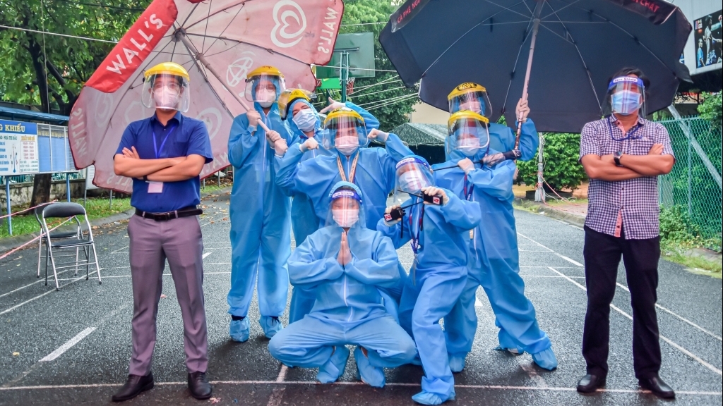 TP HCM: Tình nguyện viên đội mưa hướng dẫn người dân đi tiêm vắc xin