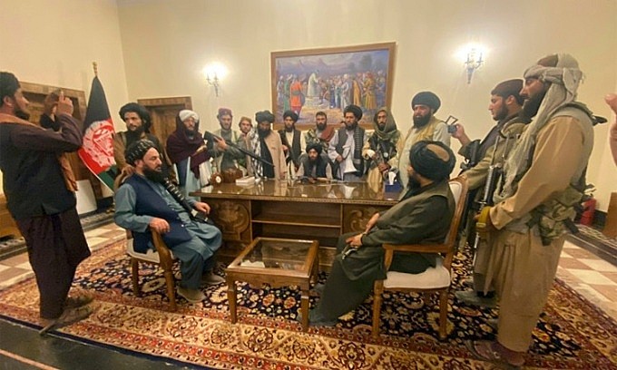   Thủ lĩnh cùng các tay súng Taliban bên trong phủ tổng thống Afghanistan ở thủ đô Kabul. Ảnh: AP.