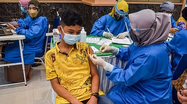 Trẻ em đang được tiêm vaccine ngừa Covid-19 tại Indonesia. (Ảnh: AFP)