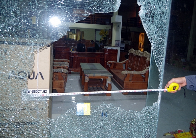 Cửa kính của cửa hàng bị bắn vỡ (ảnh CATH)