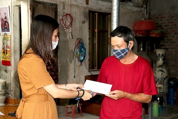 Cán bộ LĐ-TB&XH xã Bát Tràng, huyện Gia Lâm trao hỗ trợ an sinh cho người lao động khó khăn.(ảnh: P. Diệp)