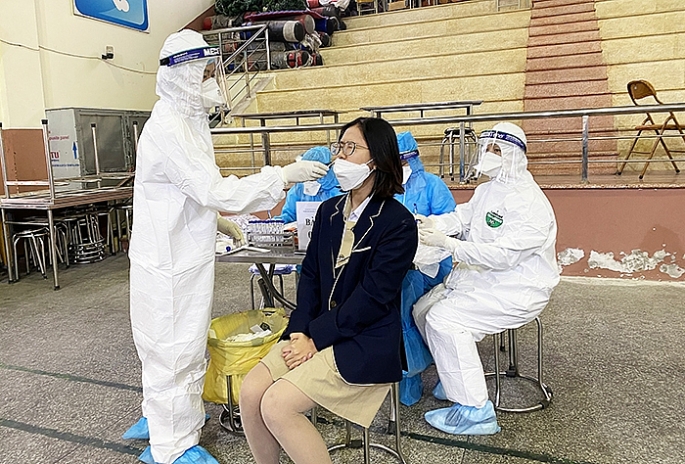 Cán bộ y tế lấy mẫu xét nghiệm của học sinh Cán bộ y tế lấy mẫu xét nghiệm của học sinh