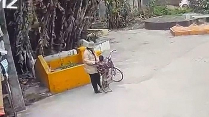 Hình ảnh người phụ nữ chở bé gái tới gần khu vực phát hiện bé L dưới cống nước. Hình ảnh người phụ nữ chở bé gái tới gần khu vực phát hiện bé L dưới cống nước.