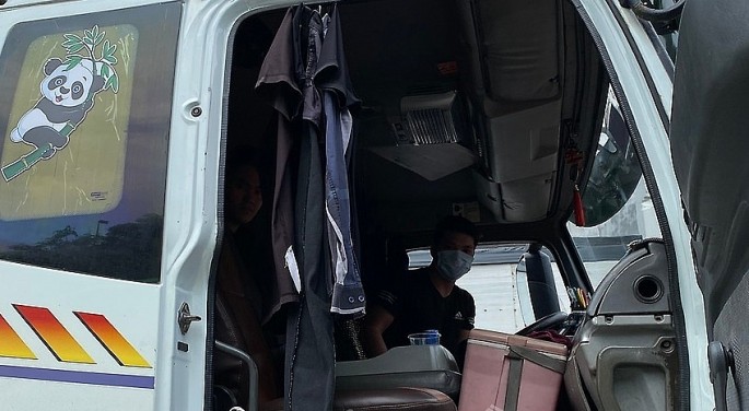 1 người nằm trốn trong phía sau ghế lái, dùng quần áo treo để nhằm tránh sự kiểm soát của cơ quan chức năng. 