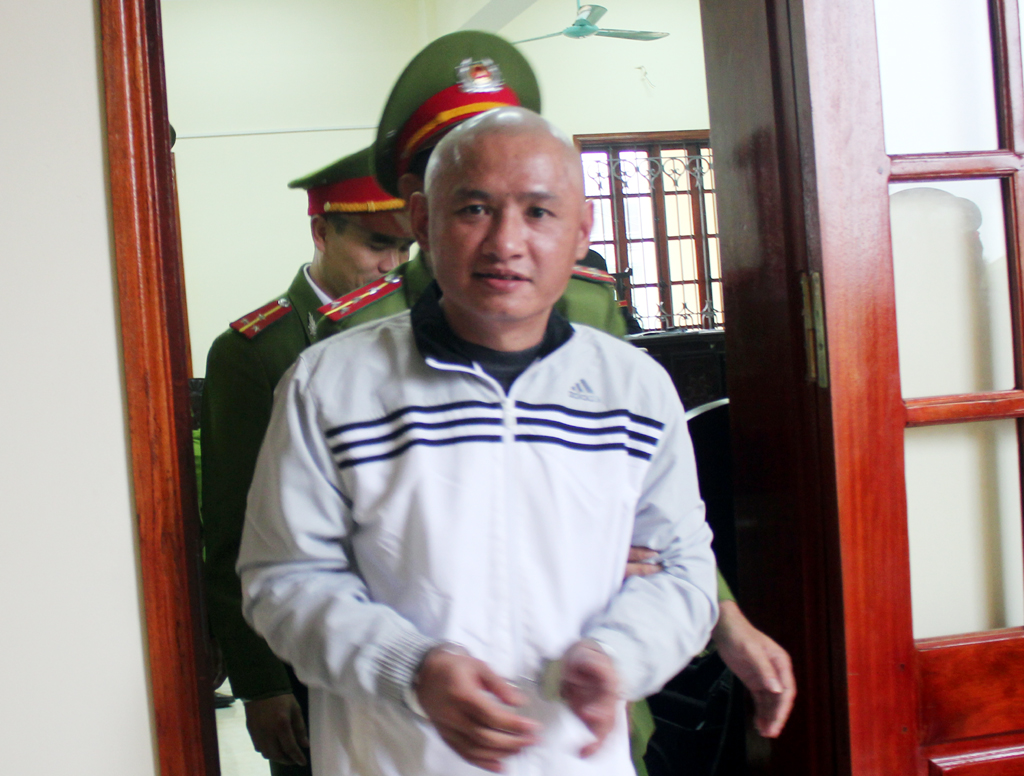 Gã tử tù bình thản nhìn thẳng ống kính phóng viên khi được dẫn giải về Trại tạm giam chờ ngày thi hành án tử hình.