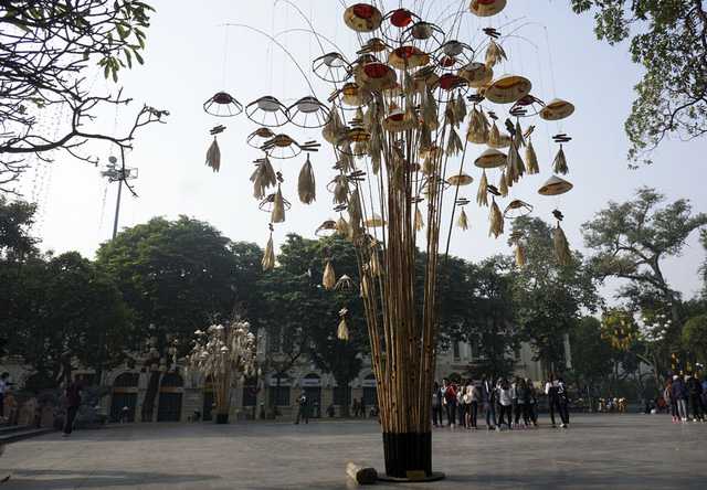 Hình ảnh cây nêu với trưng bày sản phẩm nón lá.
