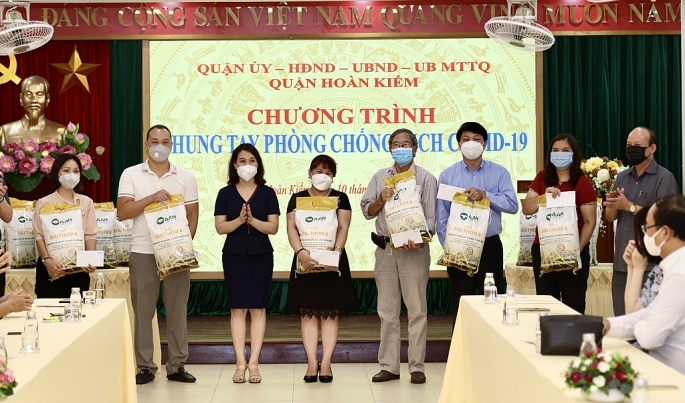 Đại diện lãnh đạo Tập đoàn T&T Group và Ngân hàng SHB trao quà cho đại diện các hộ nghèo tại 18 phường của quận Hoàn Kiếm.