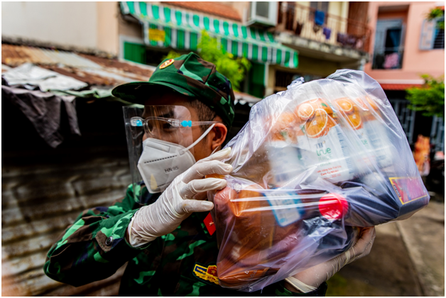 Bộ đội hỗ trợ Mặt trận Tổ quốc Phường 3 Quận Phú Nhuận đi trao túi thực phẩm tiếp tế cho người dân khó khăn vì Covid.