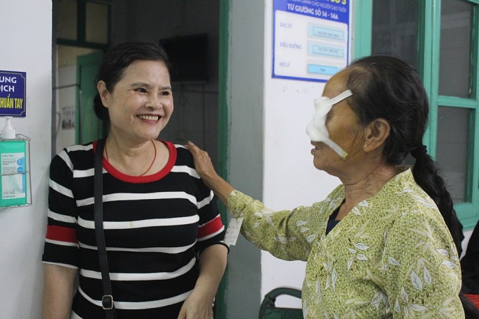 Bà Phan Thị Bính trò chuyện với những bệnh nhân tham gia chương trình mổ mắt miễn phí. Ảnh Vi Giáng