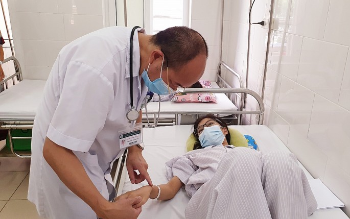 PGS-TS. Đỗ Duy Cường-GĐ Trung tâm bệnh nhiệt đới, BV Bạch Mai thăm khám cho bệnh nhân sốt xuất huyết 	      Ảnh: T.M