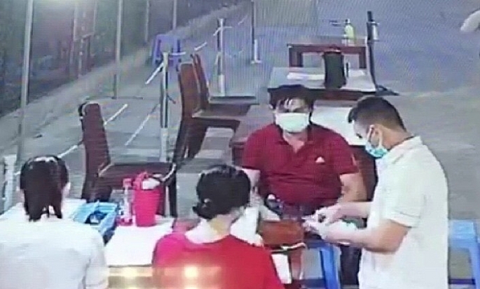 Nguyễn Văn Móm (mặc áo màu đỏ) lấy mẫu Text nhanh Covid-19 tại Bệnh viện ĐKTT An Giang (Hình chụp qua camera an ninh)
